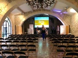 150 chaises installées devant un podium salle Royale